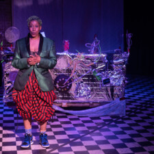 2022 Convergence 6 woman in foreground performing on stage with large art piece in background